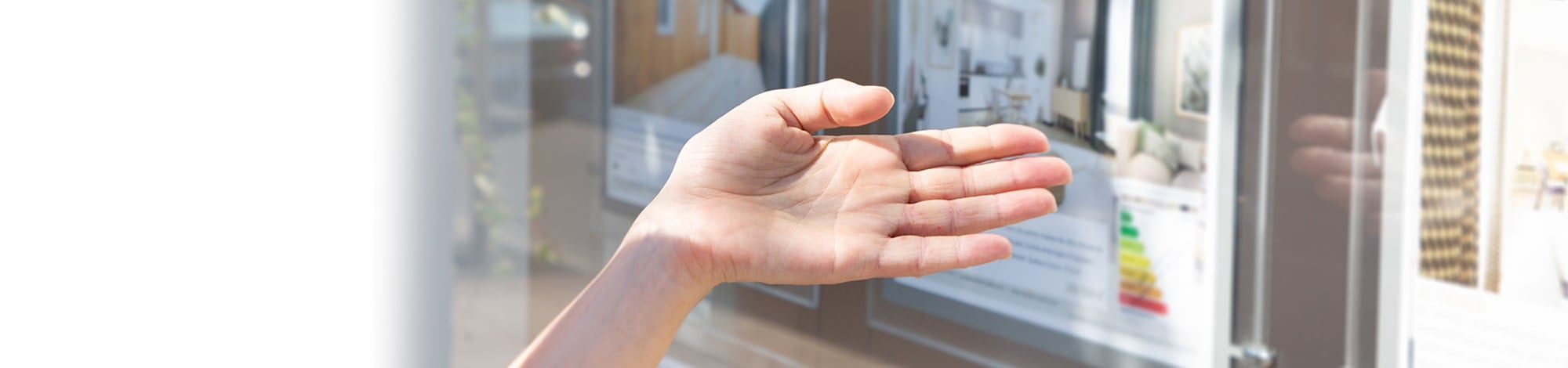 Person Pointing at a Window Showcasing Homes for Sale