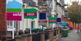 estate agent for sale signs down a uk residential street