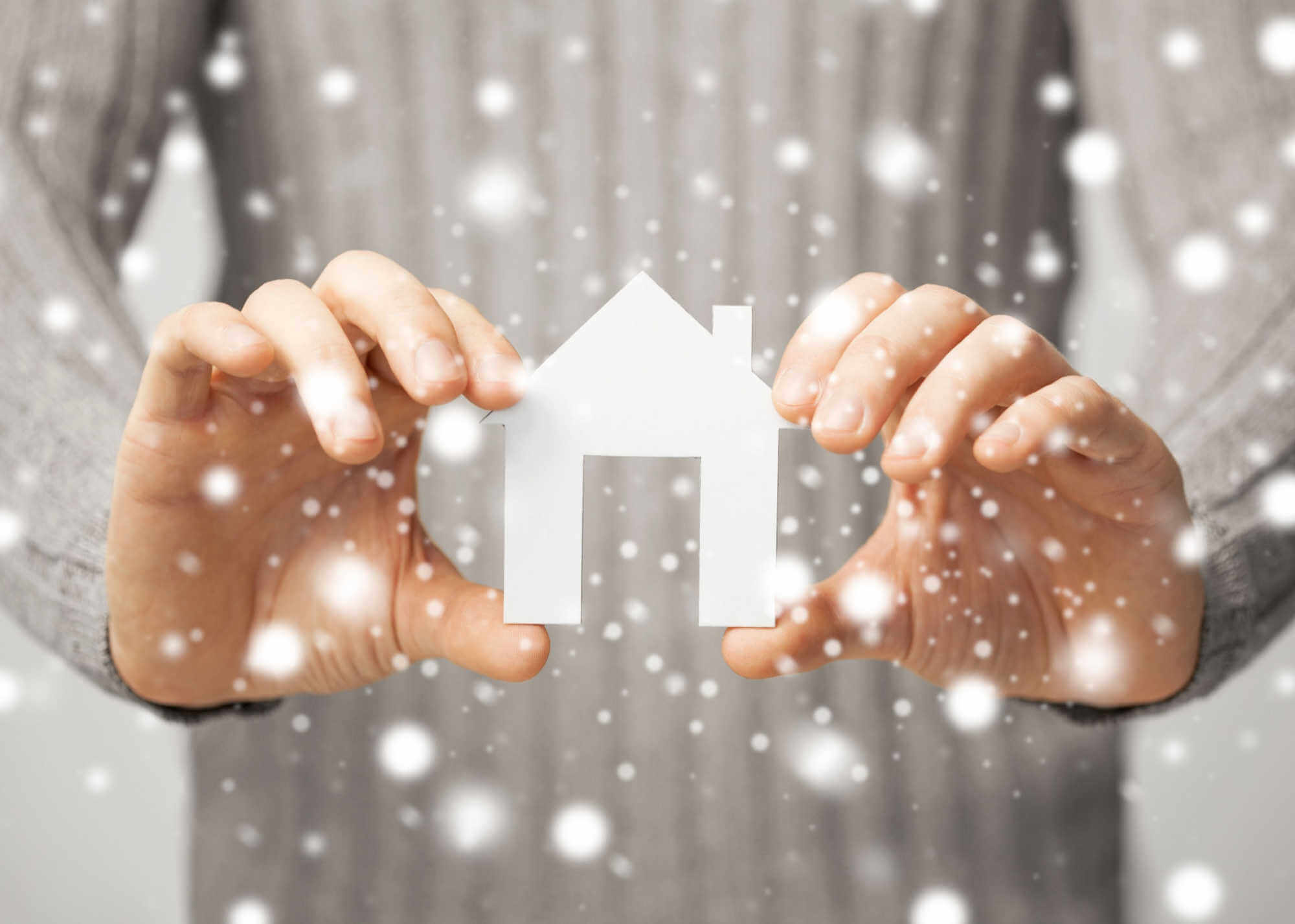 man-holding-paper-house-winter-theme