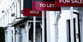 Estate agent 'for sale', 'to let' and 'sold' signage boards of street of terraced houses