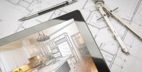 Computer Tablet Showing Kitchen Illustration Sitting On House Plans With Pencil and Compass