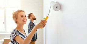 couple-repairing-painting-wall-what-not-to-fix-before-selling